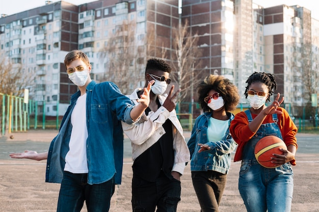 Groupe d'amis posant avec des masques chirurgicaux