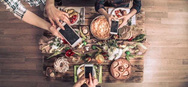 Groupe d'amis prendre une photo avec un téléphone portable avant de déjeuner. vue de dessus.