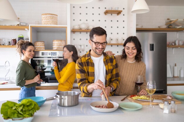 Groupe d'amis préparant un repas dans la cuisine