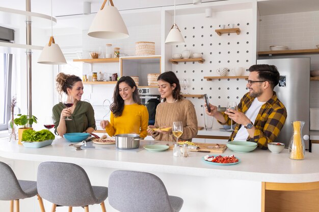 Groupe d'amis préparant un repas dans la cuisine