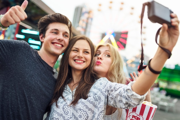 Un groupe d&#39;amis profite du parc d&#39;attraction