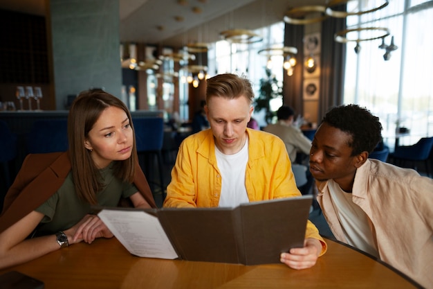 Groupe d'amis regardant le menu ensemble au restaurant