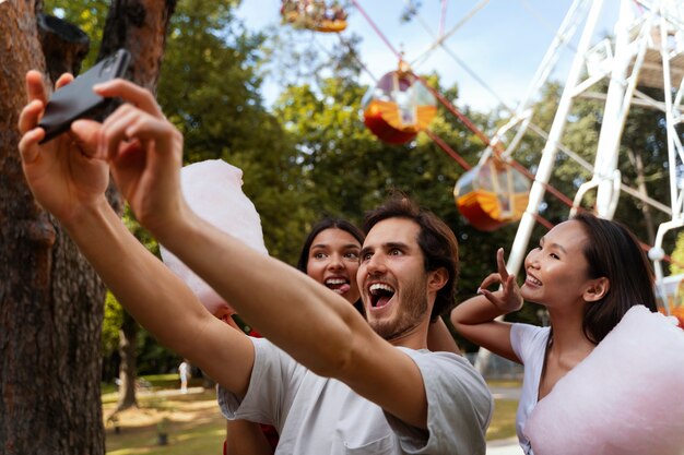 Groupe d'amis s'amusant ensemble à une grande roue