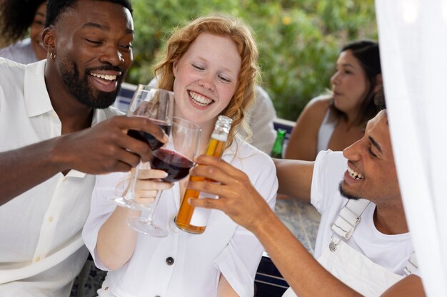 Groupe d'amis s'amusant lors d'une soirée blanche avec boissons