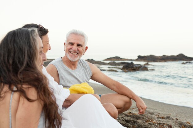 Groupe d'amis seniors passant du temps ensemble à la plage