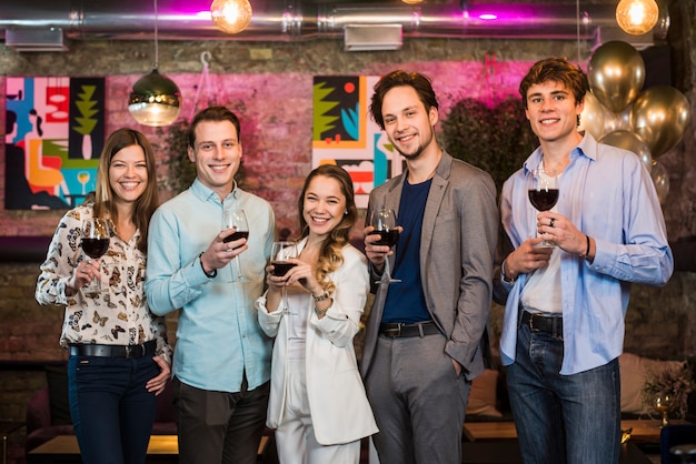 Groupe d&#39;amis en sirotant une boisson en soirée au bar