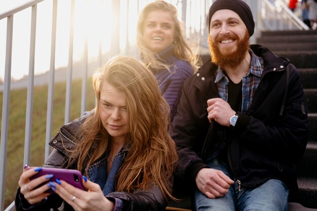 Groupe d'amis avec smartphone dans les escaliers