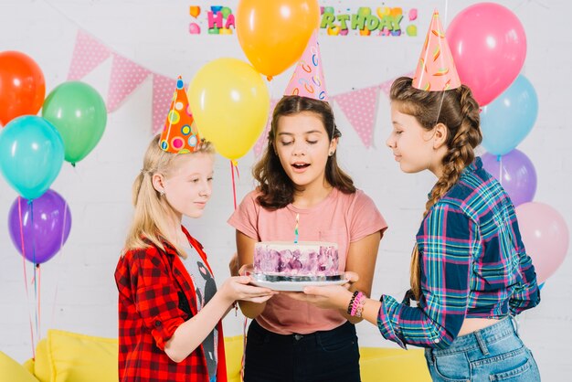 Groupe d&#39;amis tenant un gâteau d&#39;anniversaire