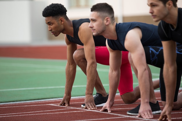 Groupe d'athlètes multiethnique concentré prêt à courir