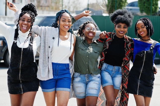 Photo gratuite groupe de cinq femmes afro-américaines marchant sur la route ensemble contre une voiture suv sur le parking