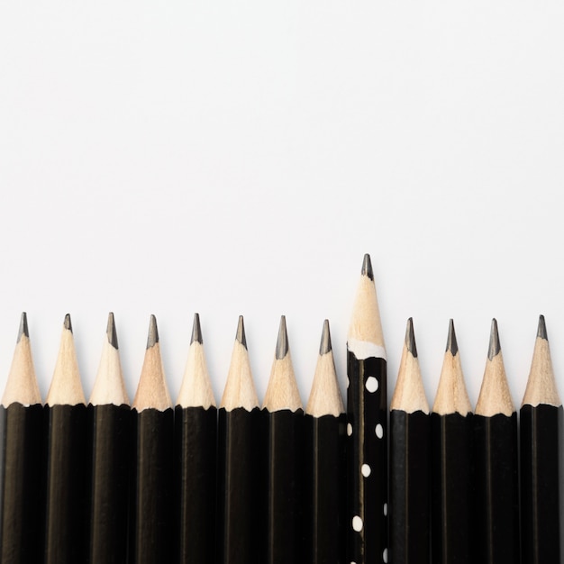 Groupe de crayons noirs et un crayon à pois