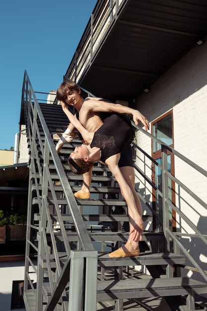 Le groupe de danseurs de ballet modernes effectuant sur les escaliers de la ville