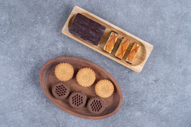 Groupe de délicieux biscuits et tranches de gâteau sur des assiettes en bois