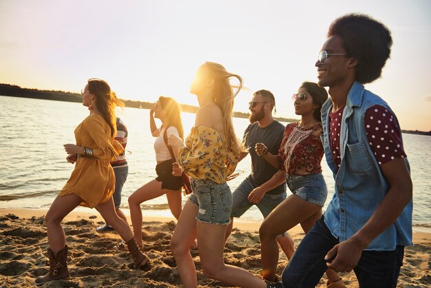 Groupe de démons s'exécutant sur la plage au coucher du soleil