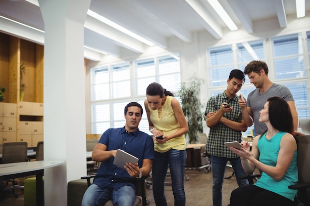 Groupe de dirigeants d&#39;entreprises utilisant la tablette numérique et télép