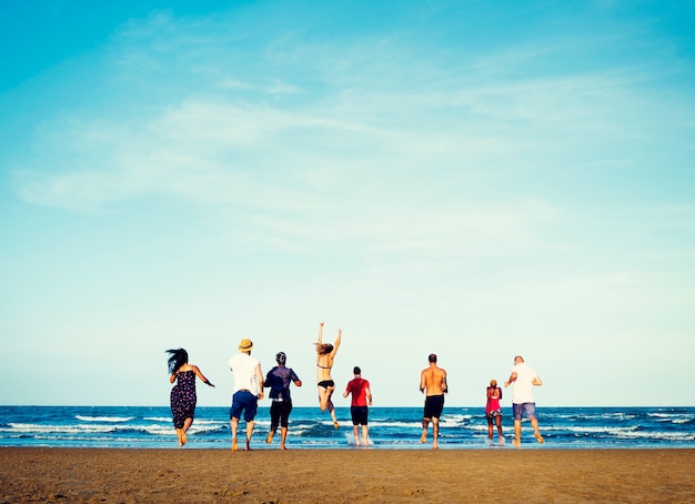 Groupe diversifié d&#39;amis qui courent à la plage