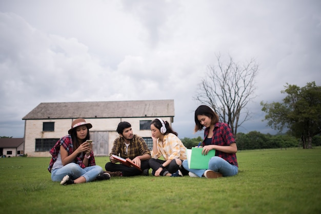 Groupe d&#39;étudiants assis au parc après la classe. Profitez de parler ensemble.