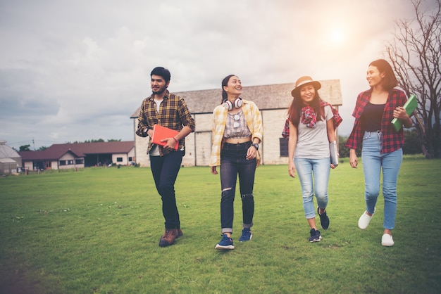 Groupe d&#39;étudiants marchant dans le parc après les cours. Profitez de parler ensemble.