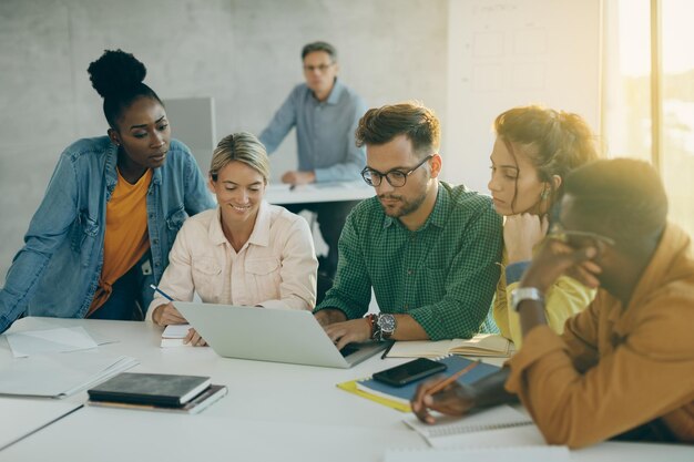 Groupe d'étudiants utilisant un ordinateur portable en classe