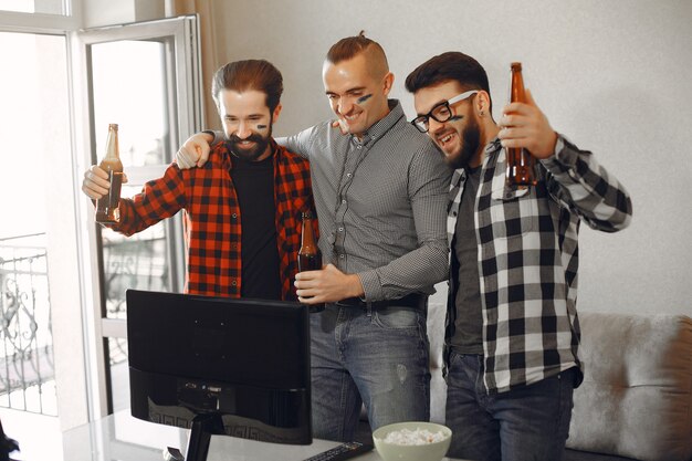 Un groupe de fans regarde le football à la télévision