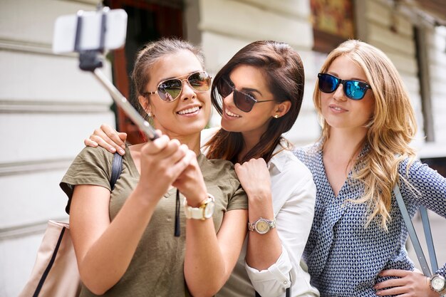 Groupe de femmes élégantes profitant de la ville et prenant une photo