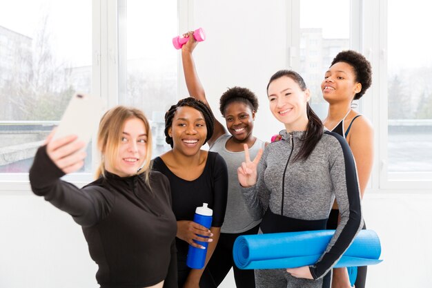 Groupe de femmes prenant des photos ensemble