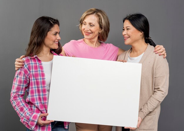 Groupe de femmes tenant une feuille de papier vierge