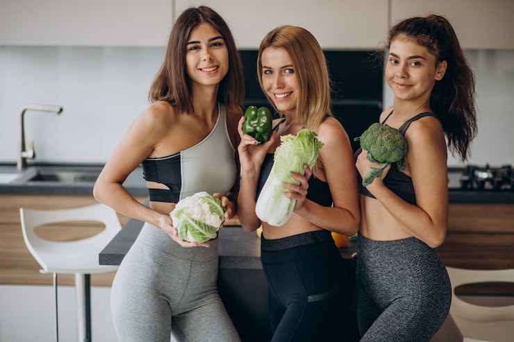 Photo gratuit groupe de filles en forme avec des légumes