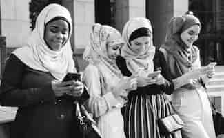 Photo gratuite groupe de filles islamiques utilisant un téléphone intelligent
