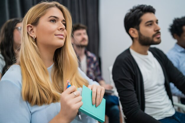 Groupe de gens d'affaires créatifs écoutant un collègue s'adressant à une réunion de bureau. Concept d'entreprise et de brainstorming.