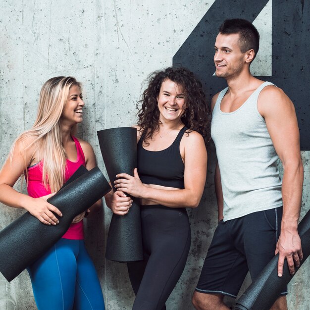 Groupe de gens heureux avec tapis de fitness