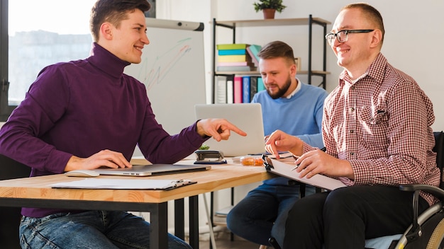 Groupe d'hommes adultes travaillant ensemble au bureau