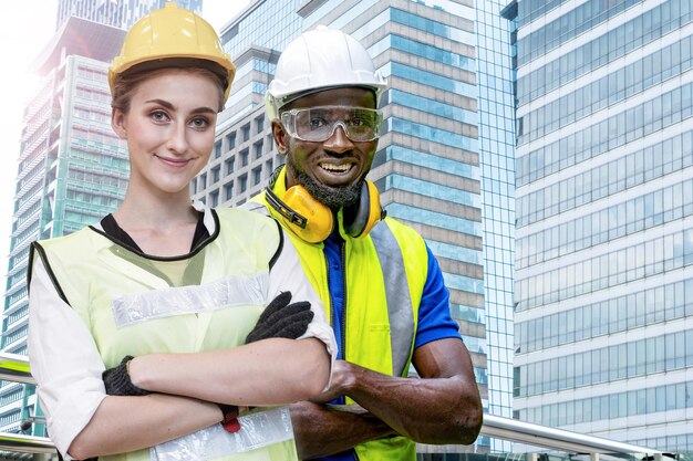 Groupe d'ingénieurs africains d'usine homme et femme debout confiants devant la façade du bâtiment
