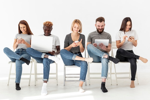 Photo gratuite groupe de jeunes amis assis sur des chaises