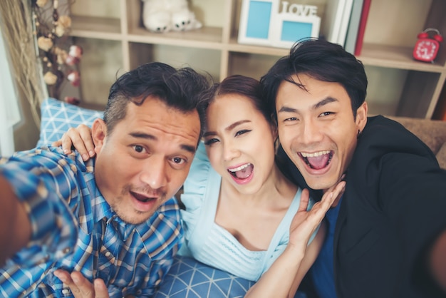 Groupe de jeunes amis faisant selfie avec un téléphone intelligent en parti.