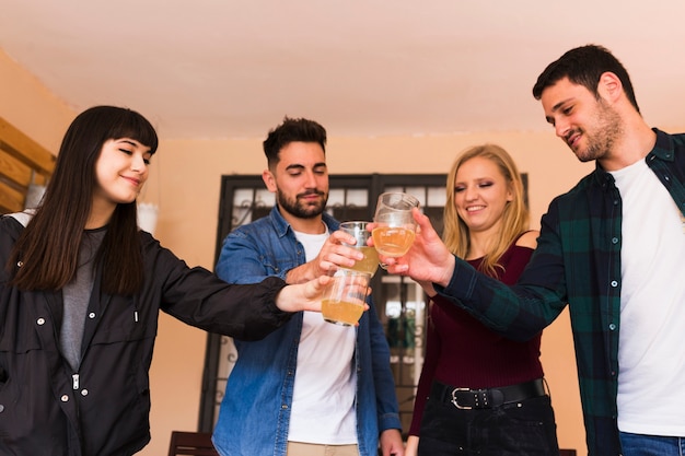 Groupe de jeunes amis heureux grillage avec un verre d'alcool