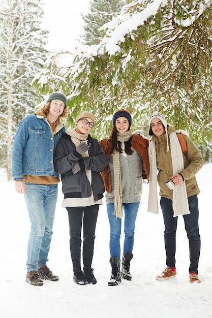 Groupe de jeunes dans la forêt d'hiver enneigé