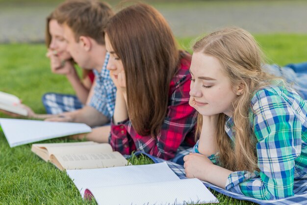 Groupe de jeunes étudiants apprenant dans un parc