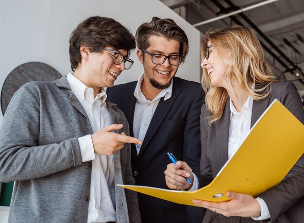 Groupe de jeunes inspirés debout et discutant d'un nouveau projet