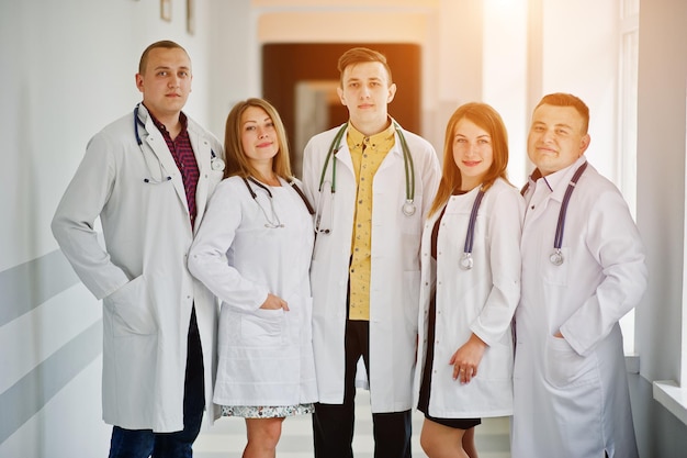 Groupe de jeunes médecins en blouse blanche posant à l'hôpital