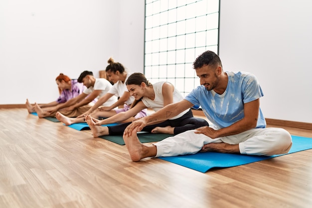 Photo gratuite groupe de jeunes souriants heureux formation yoga au centre sportif