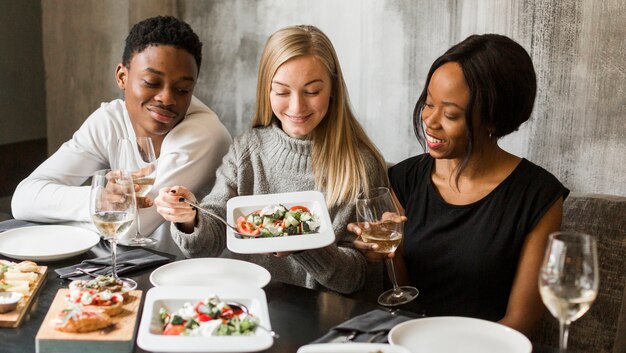 Groupe de jeunes en train de dîner ensemble