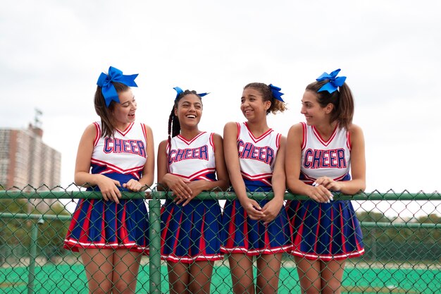 Groupe de jolies pom-pom girls adolescentes en uniforme mignon