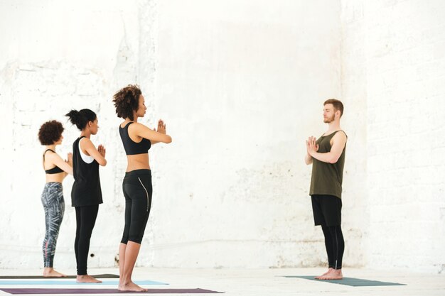 Groupe, multiethnique, gens, debout, yoga, studio