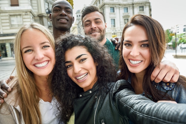 Groupe multirracial de jeunes prenant la selfie