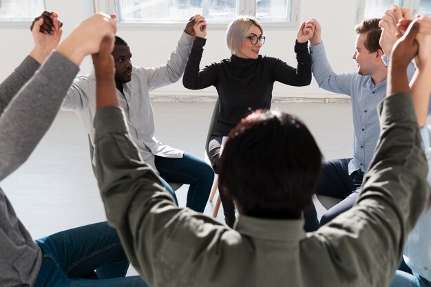 Groupe de patients levant la main