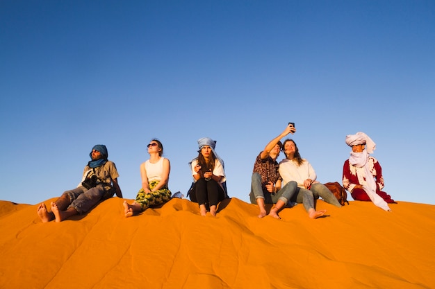 Groupe de personnes assises au sommet d&#39;une dune