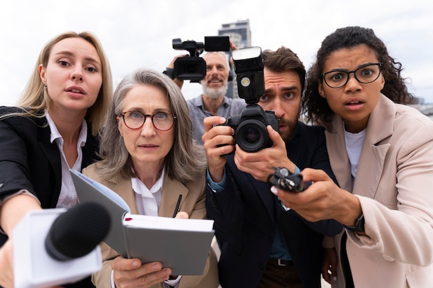 Photo gratuite groupe de personnes prenant une entrevue à l'extérieur