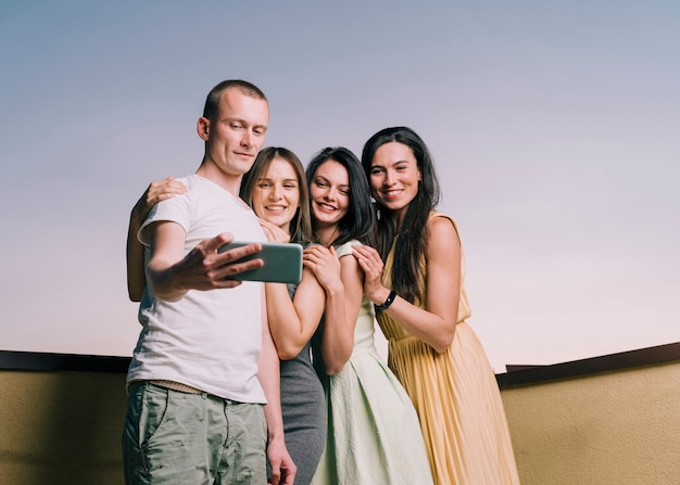 Photo gratuite groupe de personnes prenant selfie sur le toit