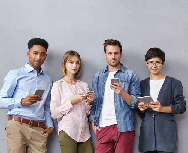 Groupe de personnes avec smartphones et tablettes